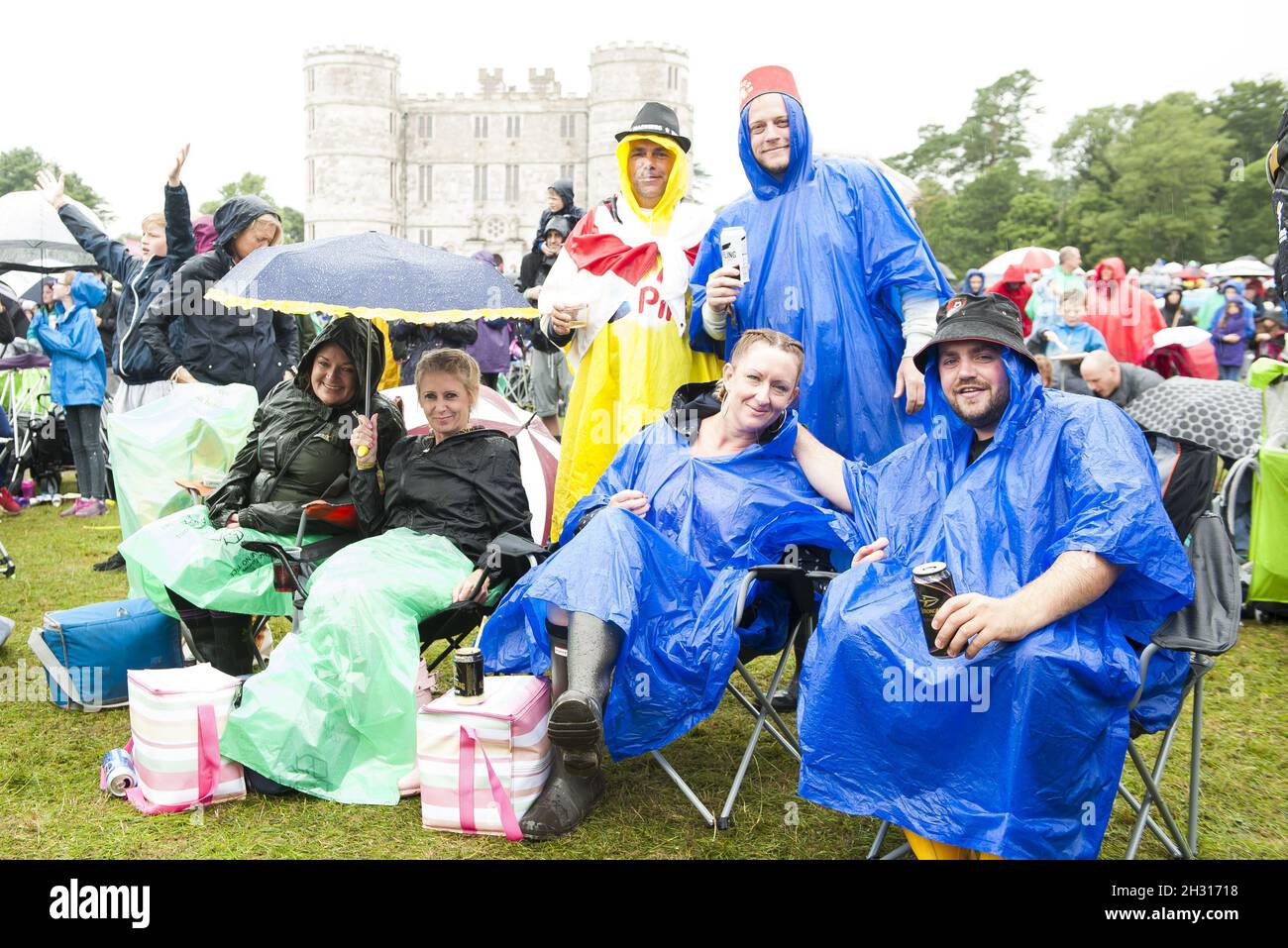 Festival goers cover from the rain at Camp Bestival 2017 Lulworth Castle - Wareham. Picture date: Saturday 29th July 2017. Photo credit should read: David Jensen/EMPICS Entertainment Stock Photo