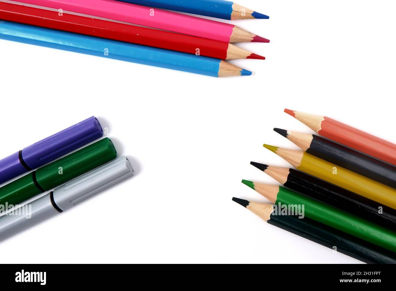 several colored pencils and markers on a white background. Stock Photo