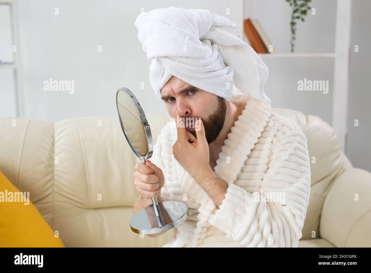 Bearded man checking his skin of face. Spa, body and skin care for male concept. Stock Photo