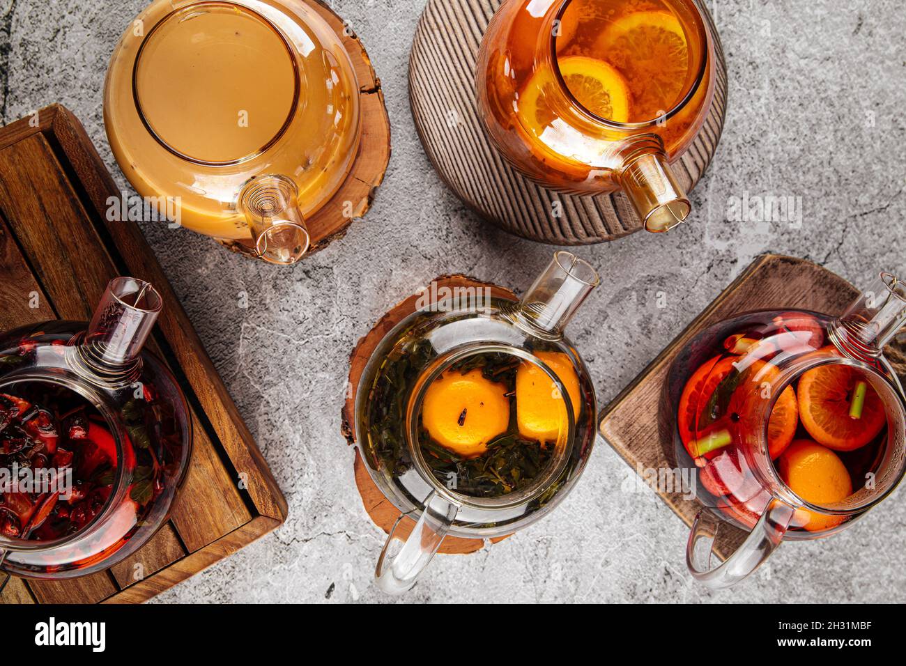 Teapots with various tea on the gray table Stock Photo