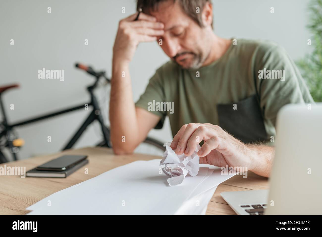 Telecommuter with creative block in home office crumpling sheet of paper, selective focus Stock Photo