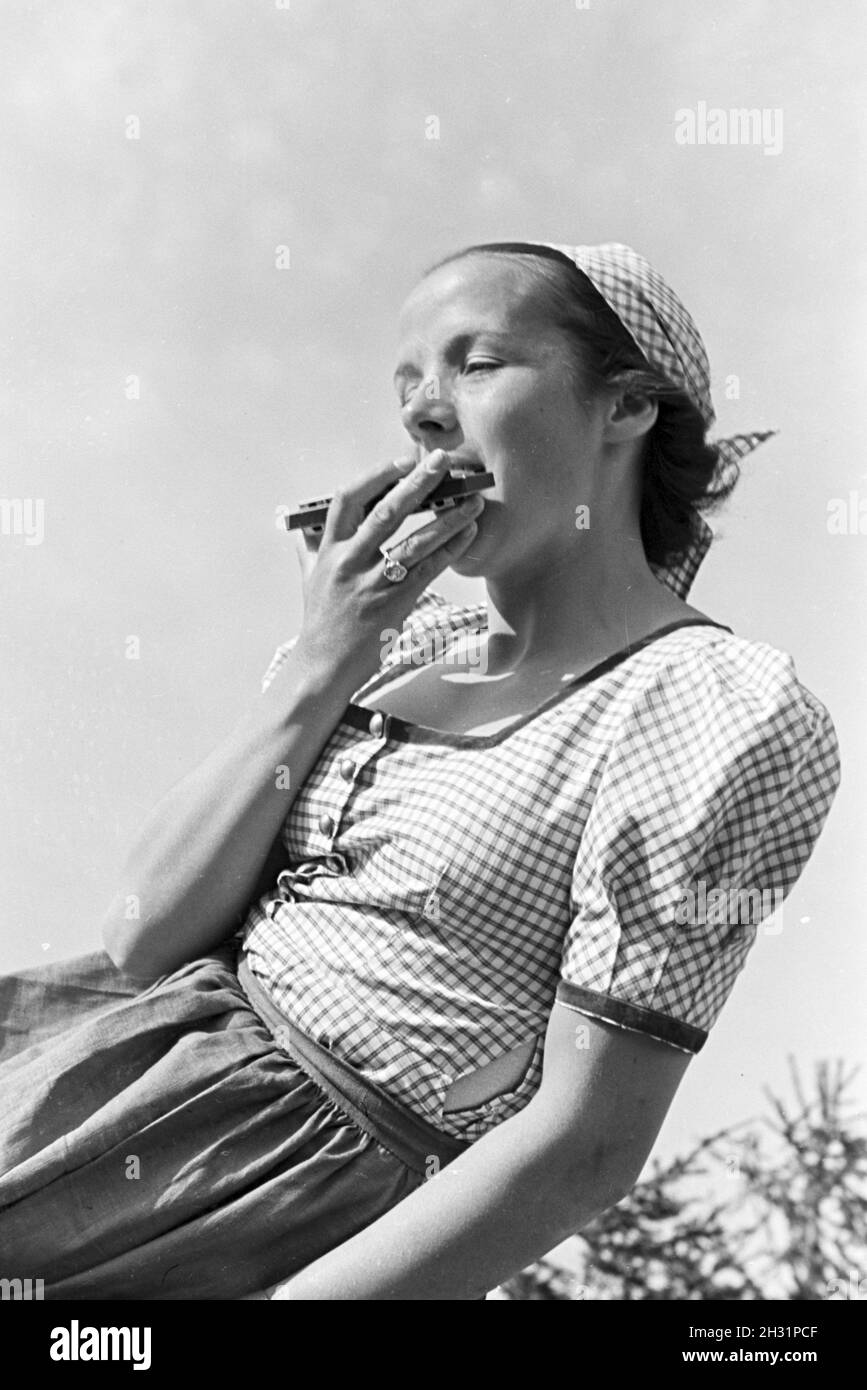 Porträt einer jungen Mundharmonikapielerin im Nordschwarzwald, Deutschland 1930er Jahre. Portrait of a young mouthorgan player in the Northern Black Forest, Germany 1930s. Stock Photo