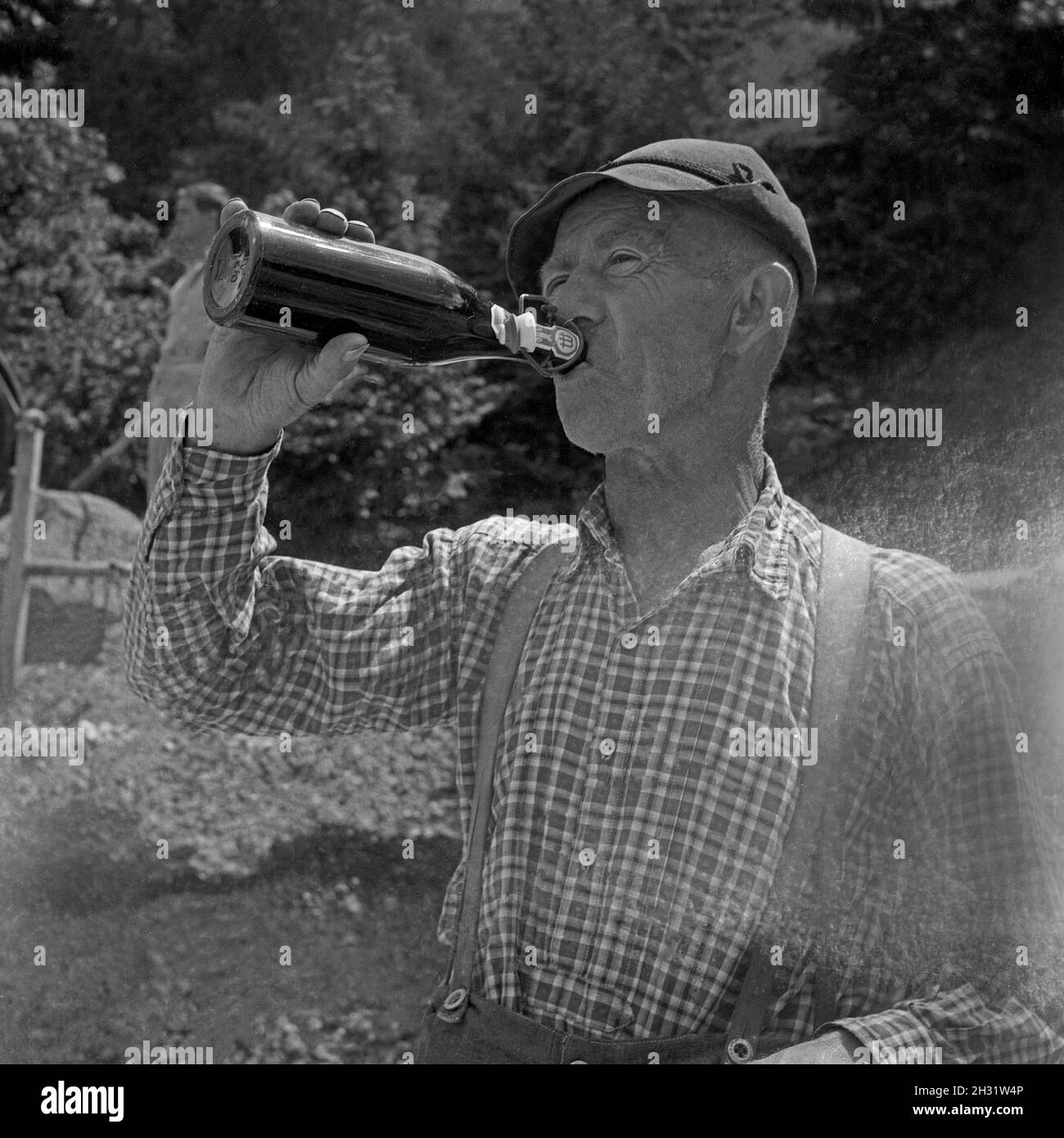 Ein Mann trinkt ein Bier während einer Pause auf der Baustelle eines
