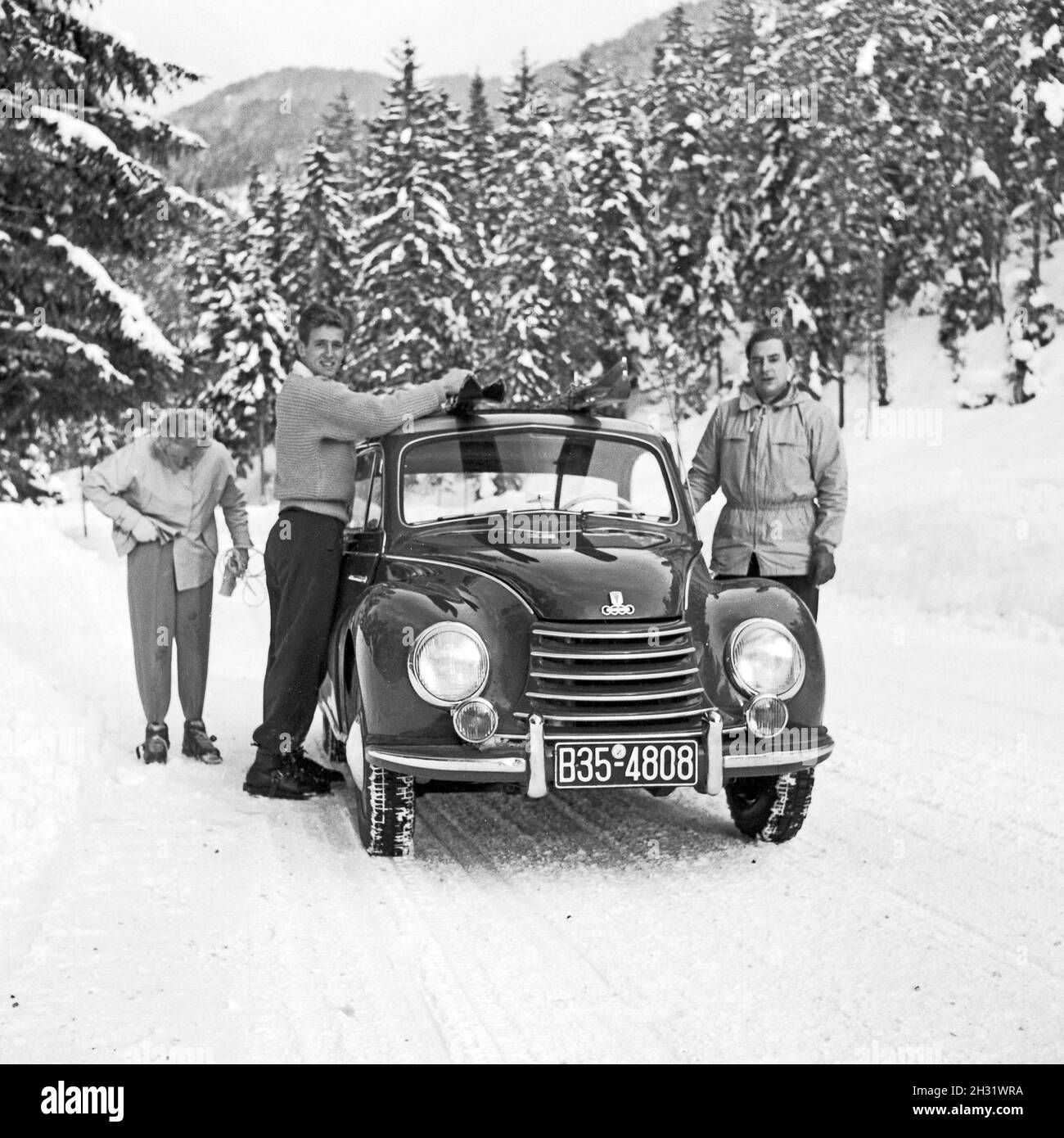 Mit dem DKW 1000 auf verschneiten Straßen in der Winterurlaub, Deutschland 1957. Going to a ski vacation with a DKW 1000 car, Germany 1957. Stock Photo