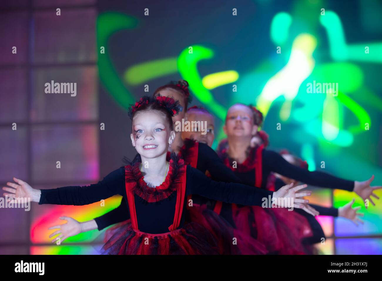 Little girls are performing a dance number. Dance for Helovinna in red ...
