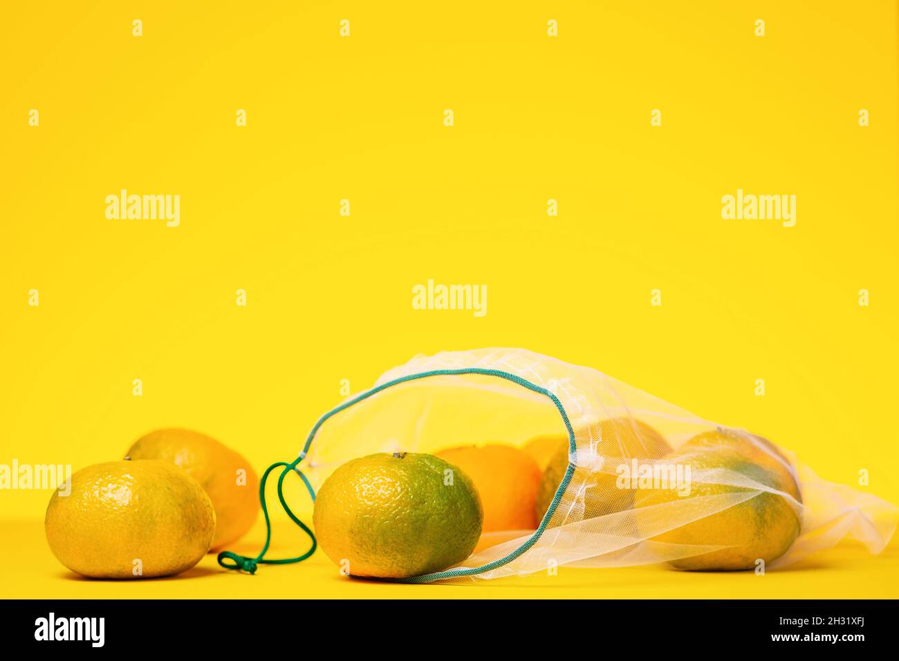https://c8.alamy.com/comp/2H31XFJ/fresh-tangerines-in-reusable-eco-friendly-mesh-bag-on-yellow-background-copy-space-zero-waste-shopping-concept-2H31XFJ.jpg