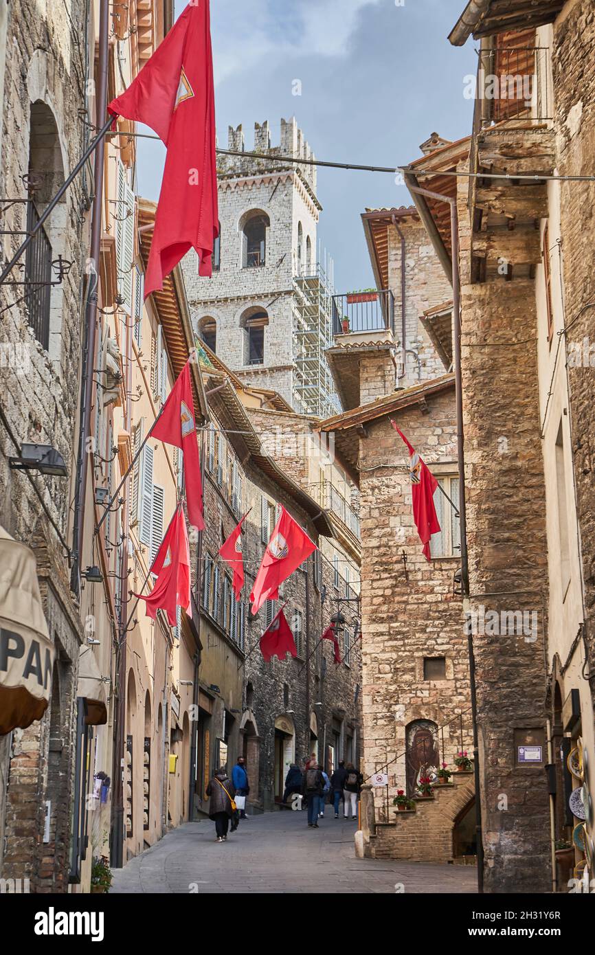 Via Portica, mittelalterliche Gasse mit roten Fahnen, hinten der Turm der Kirche Santa Maria Sopra Minerva, Altstadt, Assisi, Umbrien, Italien, Europa Stock Photo