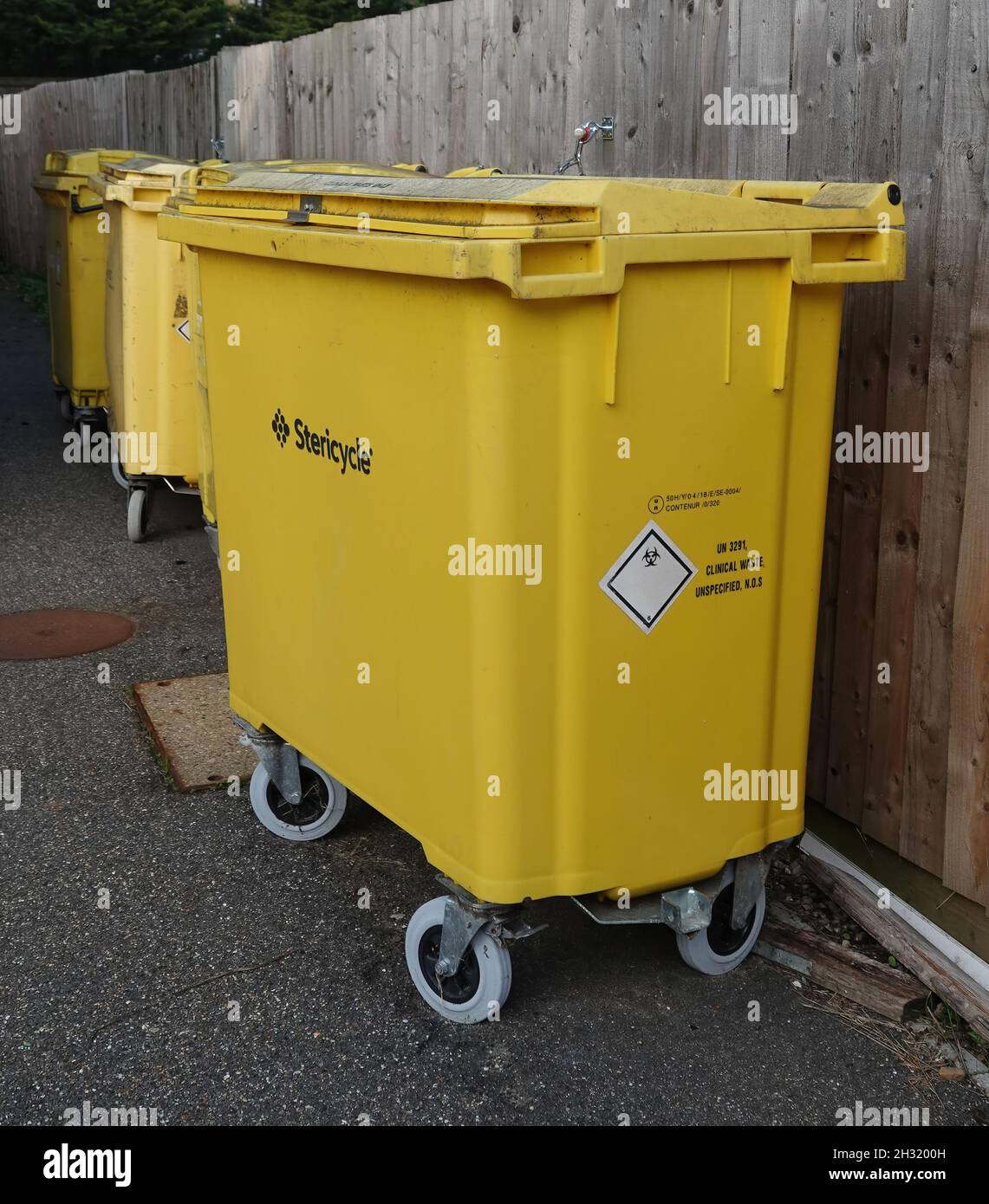 BILLERICAY, UNITED KINGDOM - Sep 29, 2021: A row of yellow medical waste disposal bins with Stericycle text outside St. Andrews Centre Stock Photo