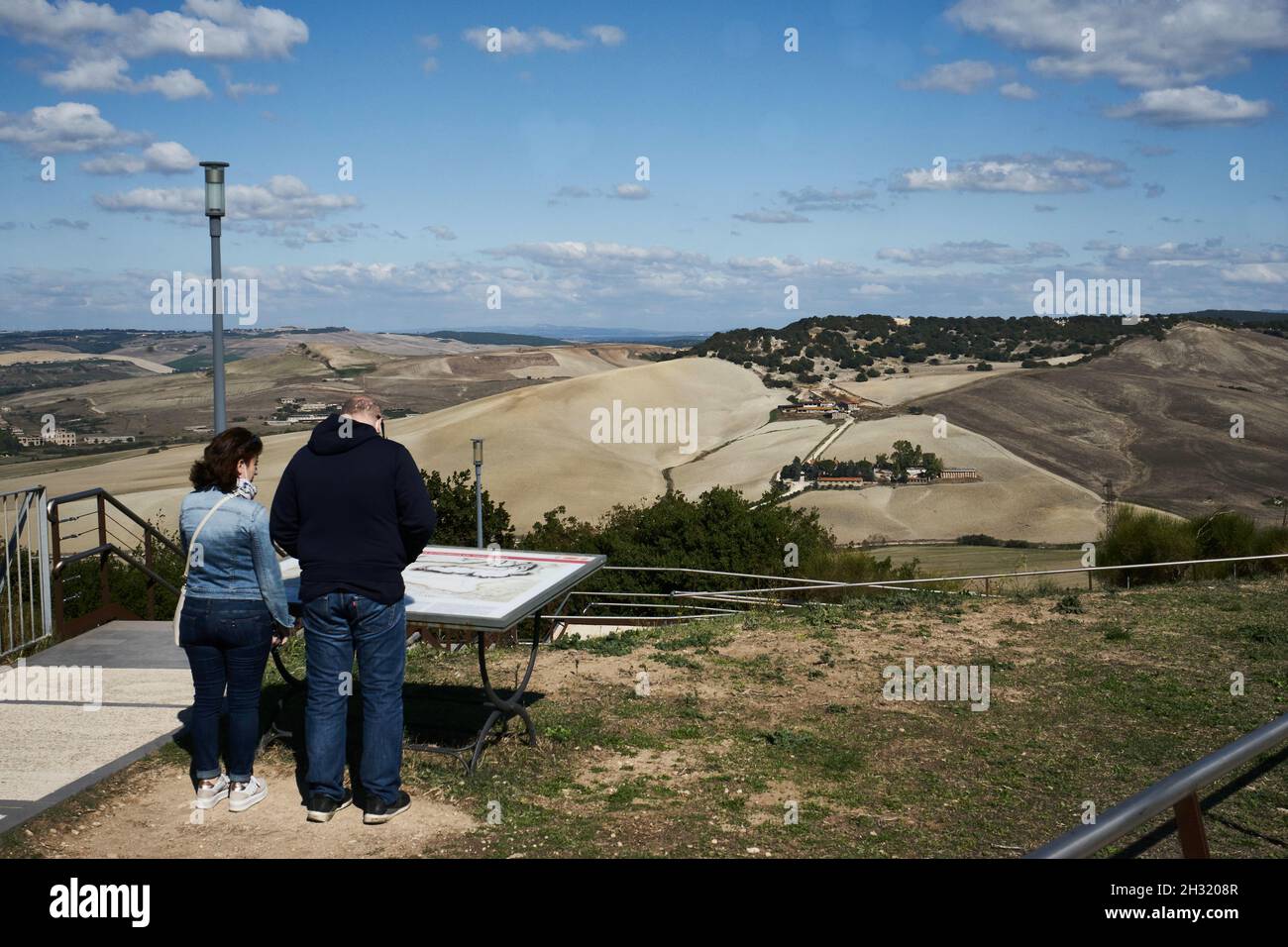 Zwei Touristen an Aussichtspunkt auf dem Gelände der Necropoli di Tarquinia,  Landschaft und abgeerntete Felder, bei Tarquinia, Latium, Italien Stock Photo