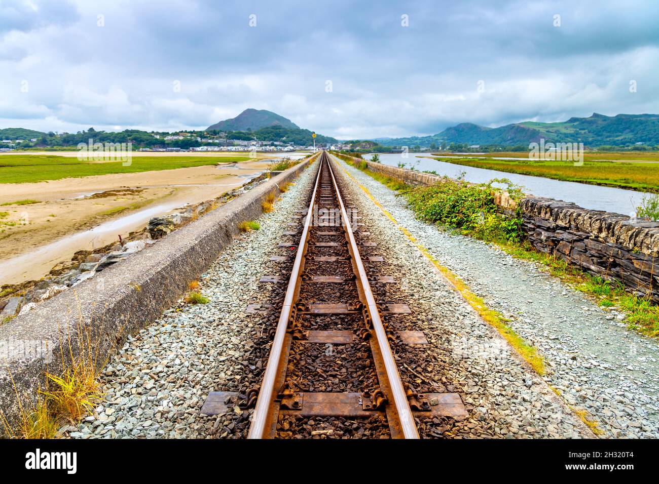 Ffestiniog Railway train tracks crossing the Porthmadog Cob (Canol ffordd Y Cob Porthmadog), Snowdonia, Wales, UK Stock Photo
