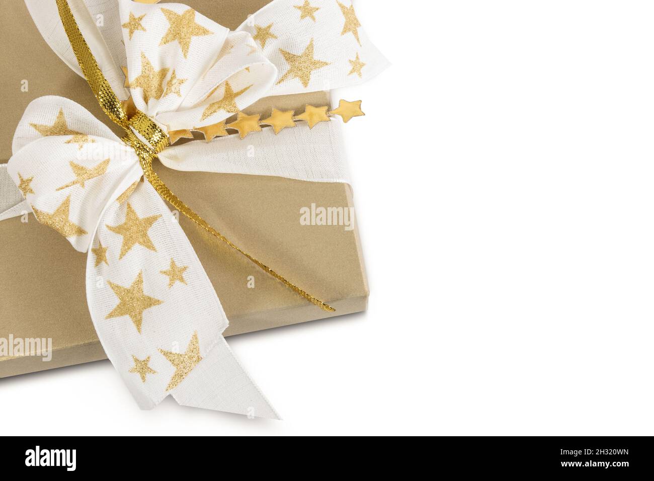 Golden gift box decorated with stars on bow isolated on white background. Stock Photo