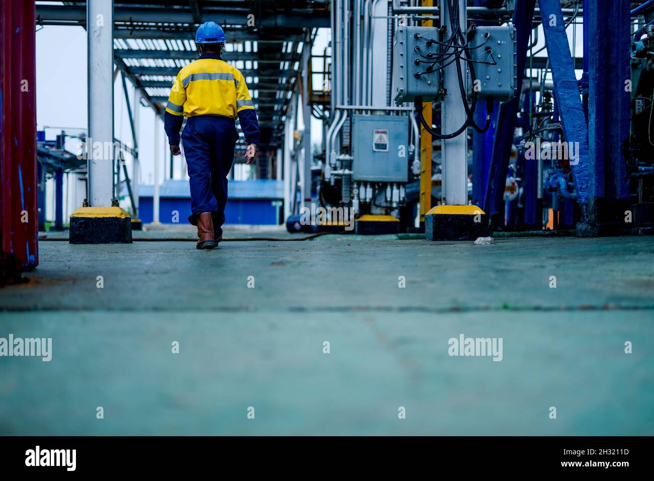Man walking with coverall in a Plant Stock Photo