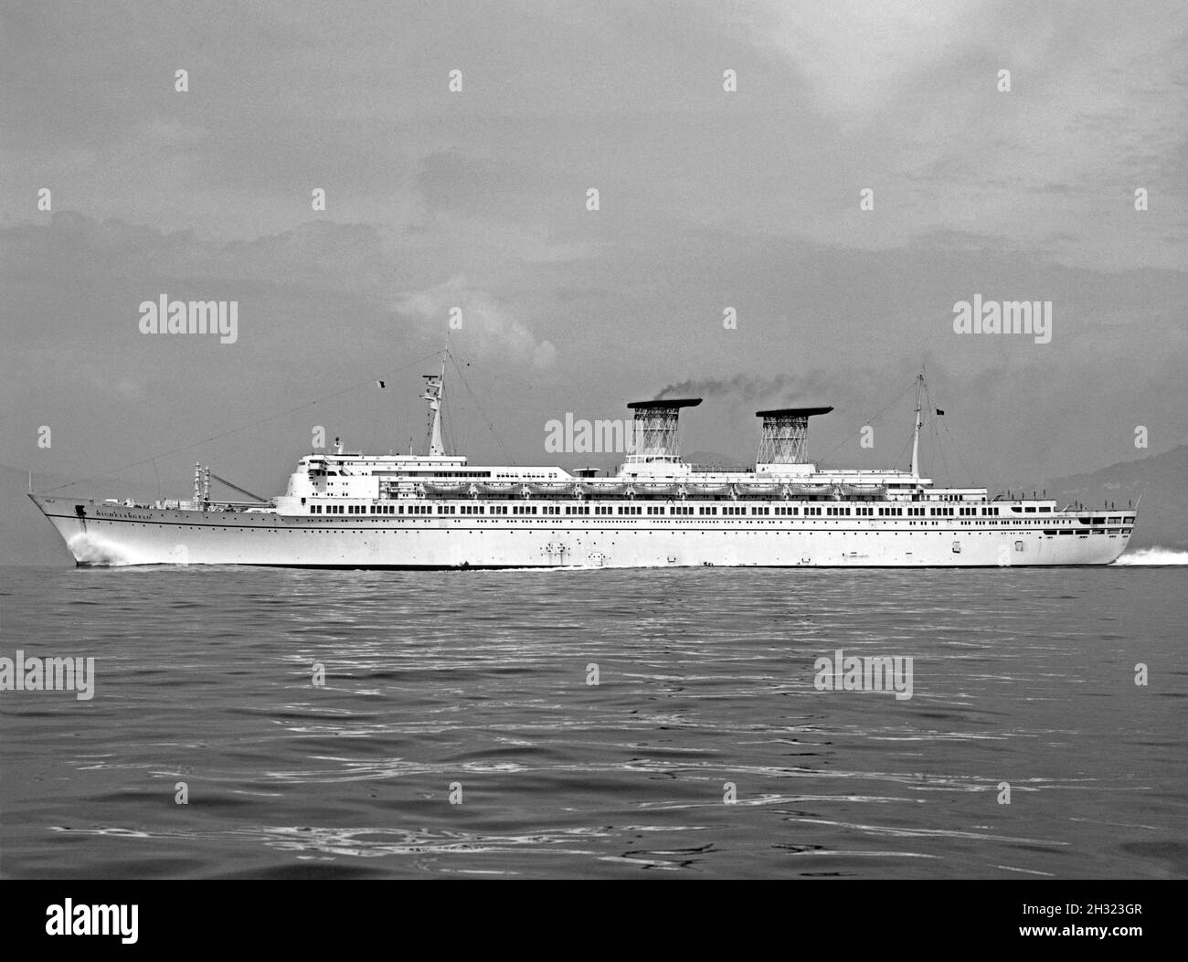 SS Michelangelo at sea in the late-1960s. The ship was an ocean liner built in 1965 for Italian Line in Genoa, Italy. She was one of the last ships to be built for the North Atlantic route, along with her sister ship was the SS Raffaello. Note the funnels, where an intricate trellis-like pipework allowed wind to pass through the funnel and a large smoke deflector fin on the top. The design proved to be very effective. The ship ended up in Bandar Abbas, Iran where she spent 15 years as a floating barracks. Plans to reconstruct her as the cruise ship came to nothing and in 1991 she was scrapped. Stock Photo