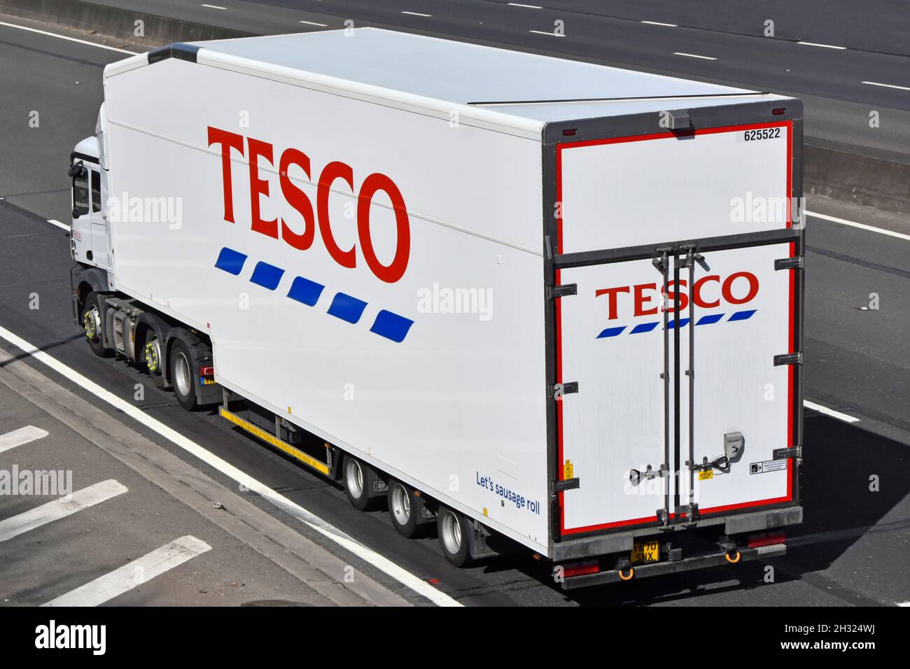 Side & back view Tesco supermarket hgv food supply chain juggernaut lorry truck & articulated trailer advertising business brand name logo UK motorway Stock Photo