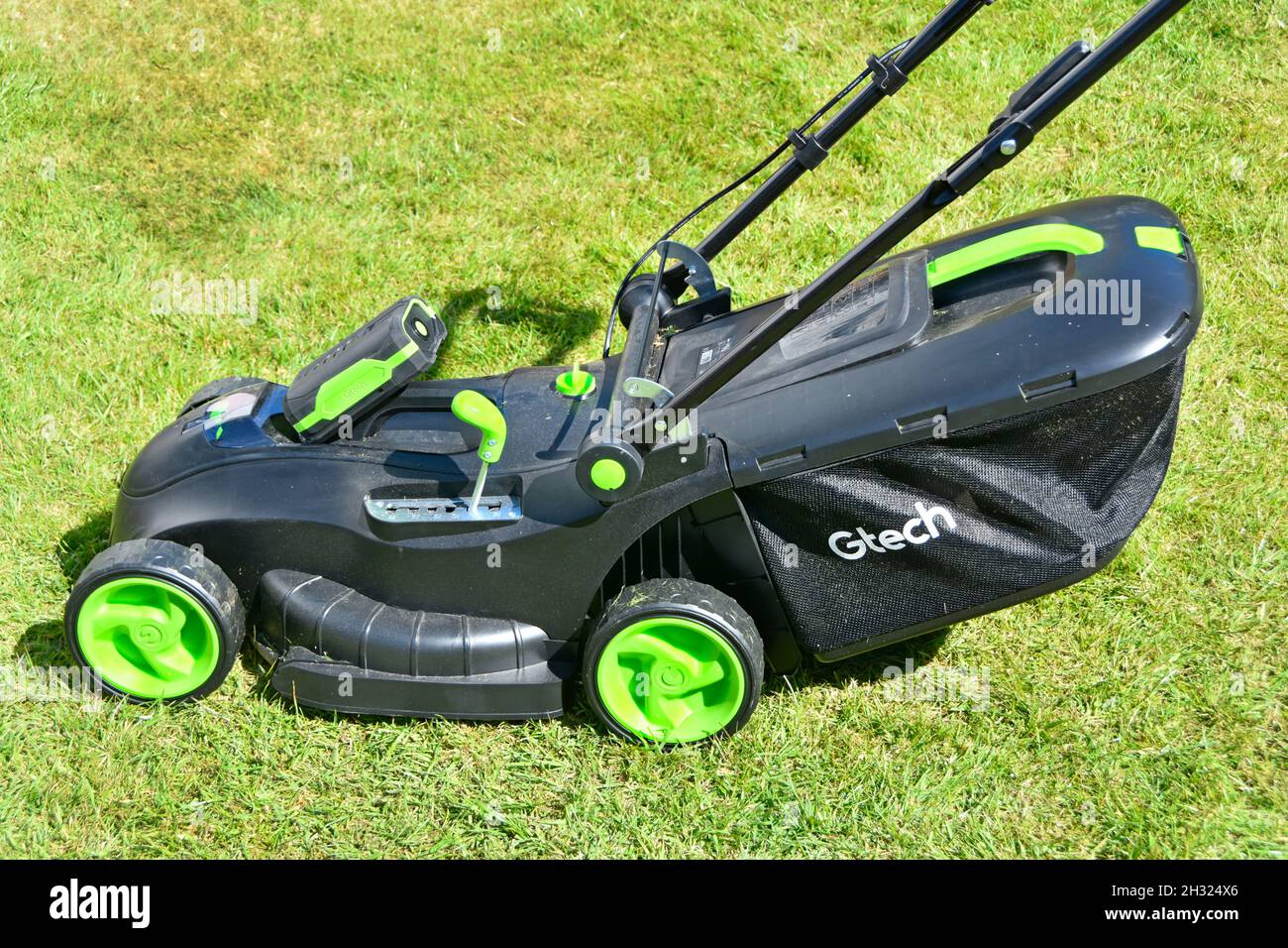 Close up Gtech cordless lithium battery exposed to illustrate drives power unit on home garden lawn lawn motor mower tool with grass box in England UK Stock Photo