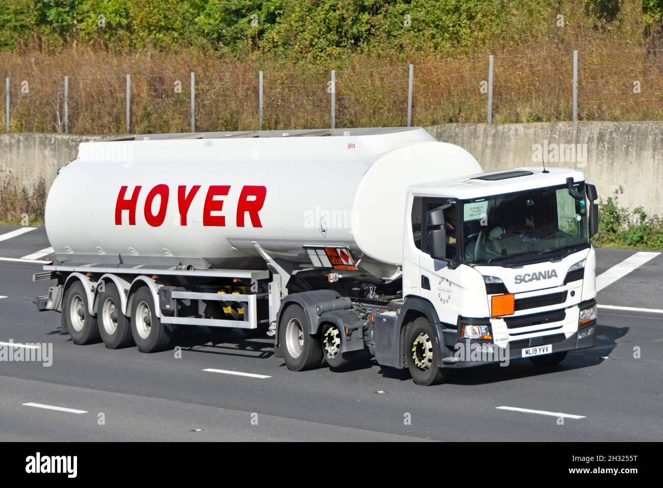Side & front view Hoyer business in bulk logistics for petroleum chemical industry hgv lorry truck brand logo on tanker trailer driving on UK motorway Stock Photo