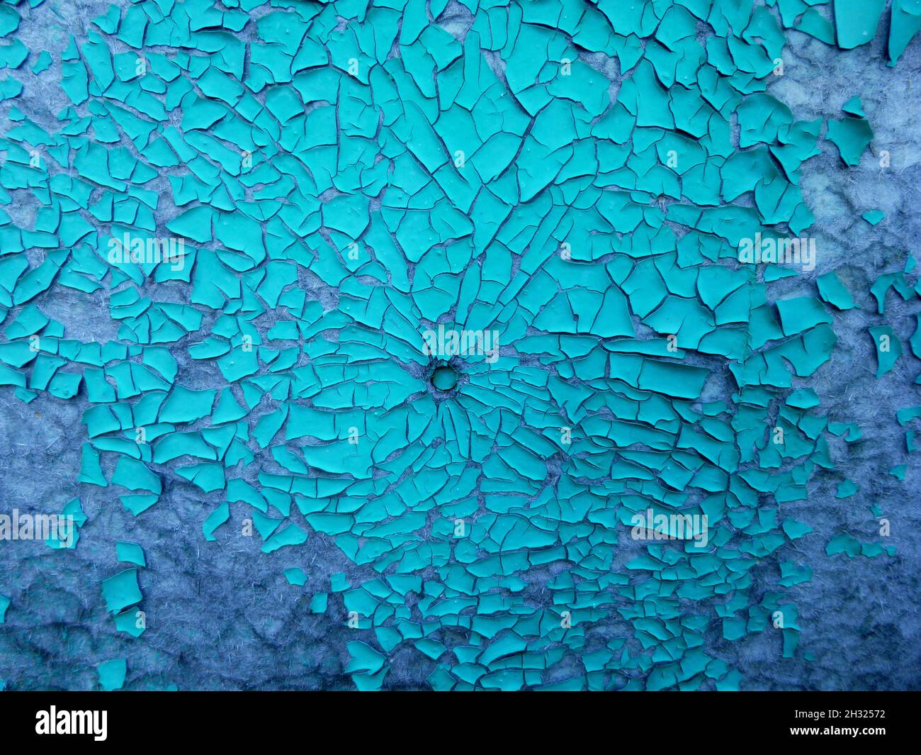 Blue peeling paint on the wall. Weathered rough painted surface with