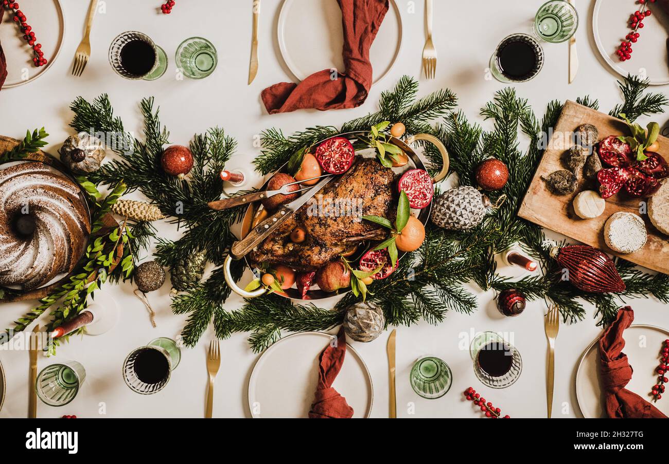 Flat-lay of Christmas table setting with chicken, wine and decorations Stock Photo