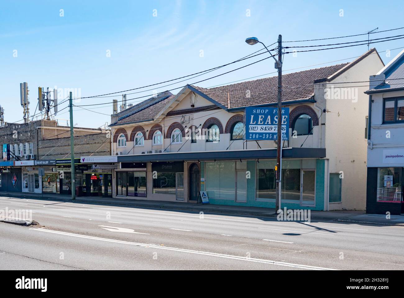 The shopping strip on the Pacific Highway is a mix of building ages including this 2 level multi unit dwelling C. interwar with corbel brick windows Stock Photo