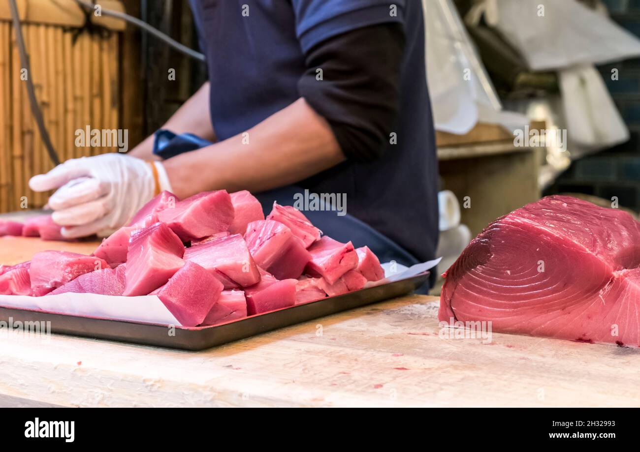 Fishmonger cuts tuna fish for sale at the Tsukiji fish market, largest in the world, Tokyo, Japan Stock Photo