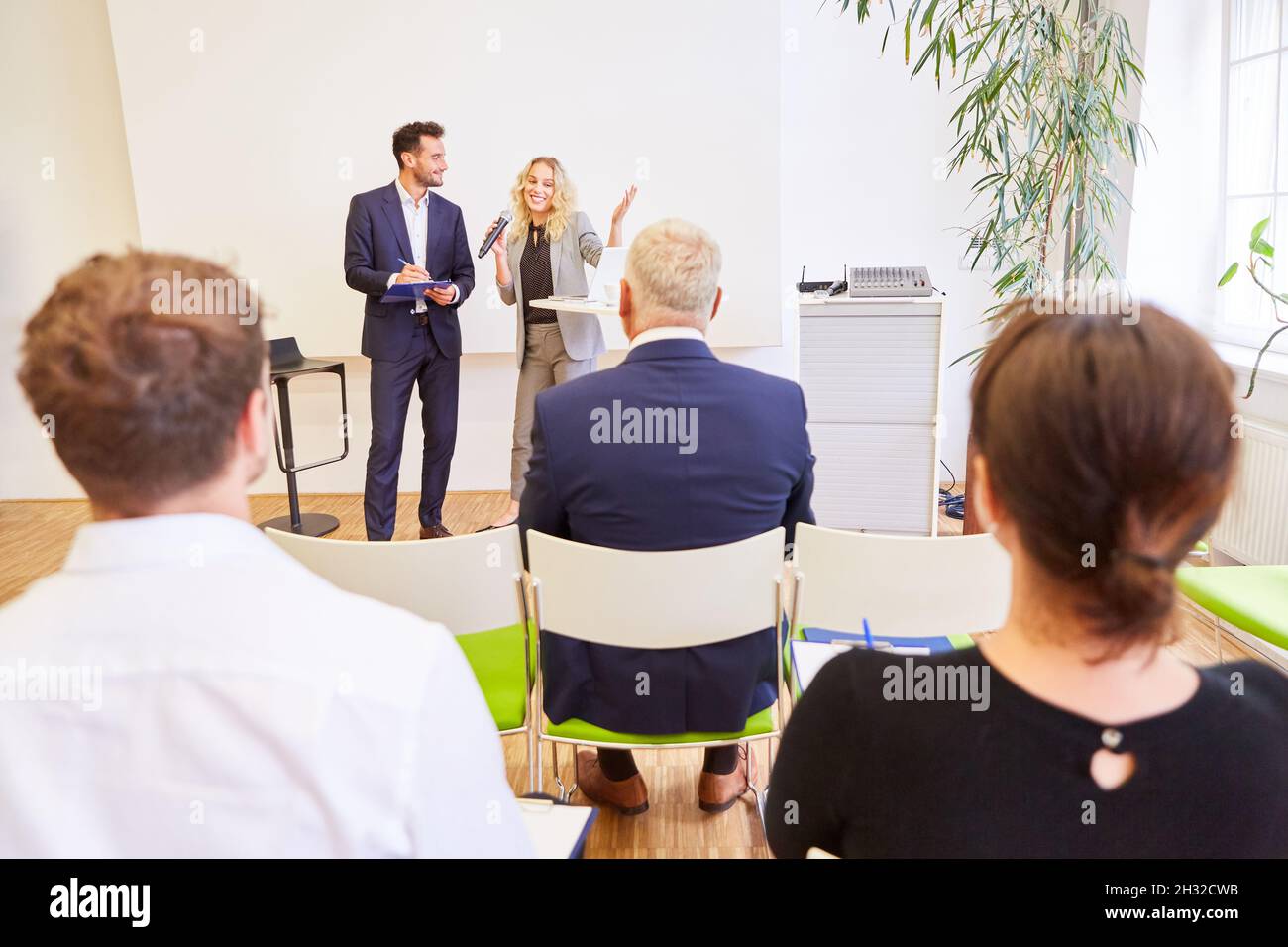 Team of speakers at lecture and presentation at business conference with audience Stock Photo