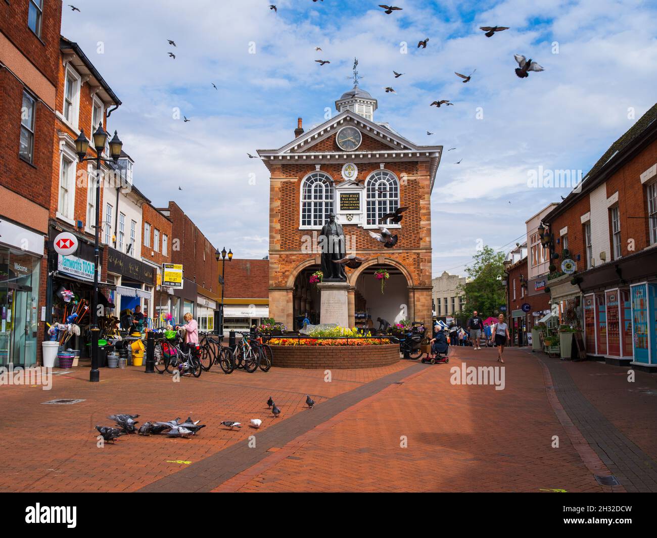 TAMWORTH, UNITED KINGDOM - Sep 22, 2021: A shot of people and pigeons at Tamworth Town Hall in Tamworth, Staffordshire, England, UK Stock Photo