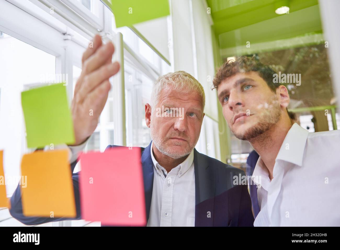 Consulting consultant and young businessman creatively brainstorming with sticky notes Stock Photo