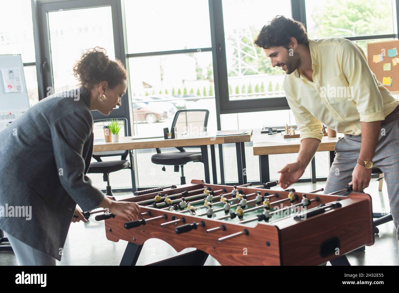 https://c8.alamy.com/comp/2H32E55/side-view-of-interracial-business-people-playing-table-football-in-office-2H32E55.jpg