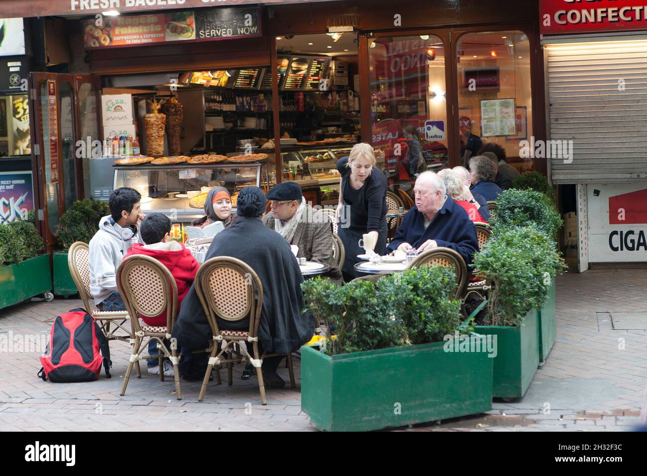 London, UK - 20 September 2021, People are in cafe. Big family orders pizza at a cafe in Leicester Square Stock Photo