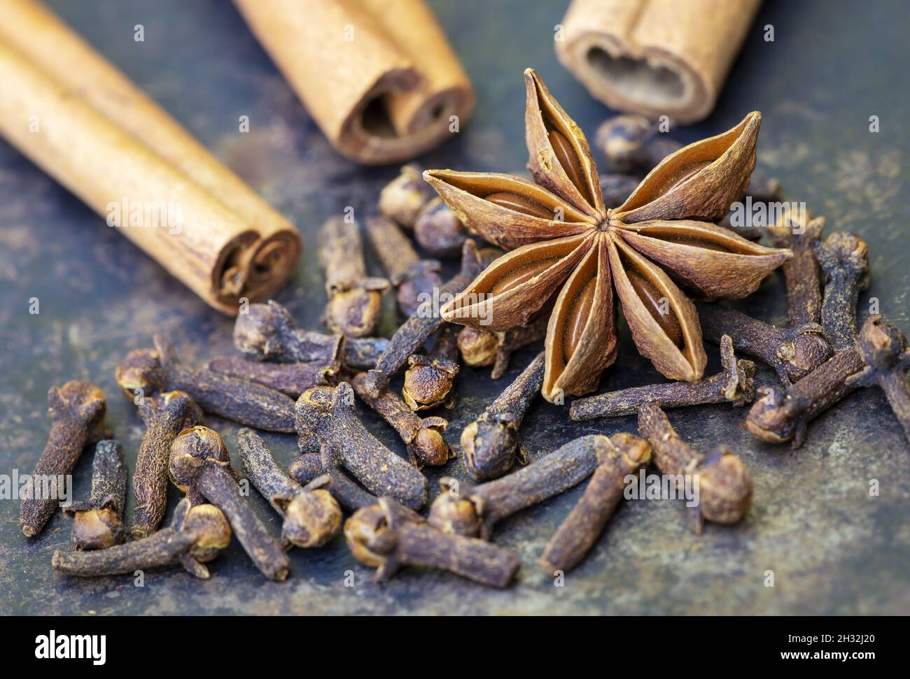 Aromatic christmas holiday spices, star anise and cloves on metal