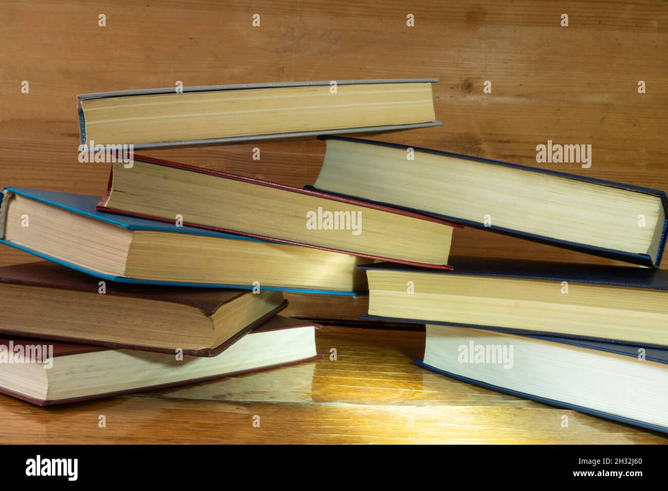 The Stack of the books rests upon wooden regiment. Subjects in closet close-up Stock Photo