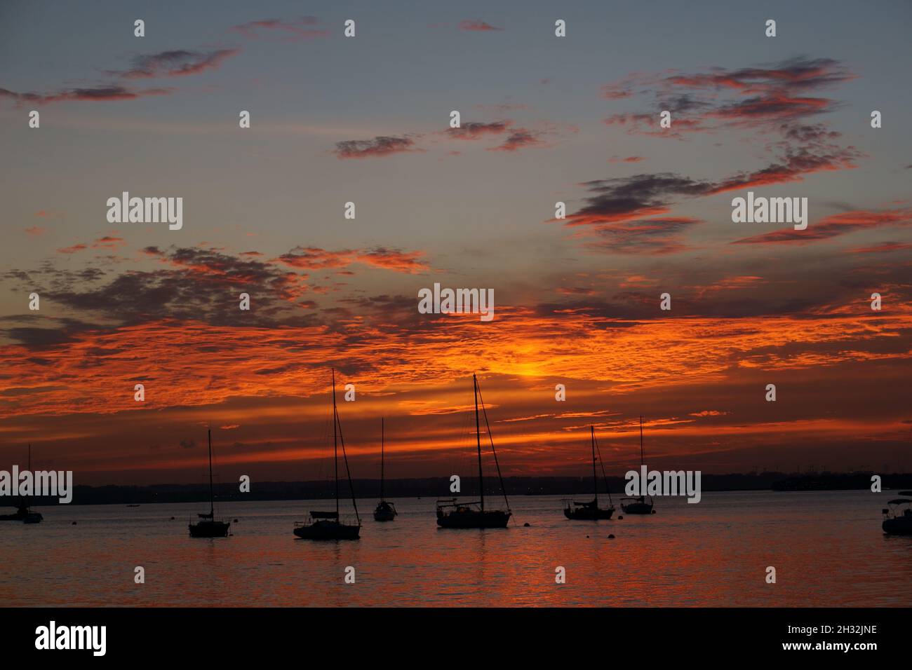 Sunset with sailboats anchored Stock Photo