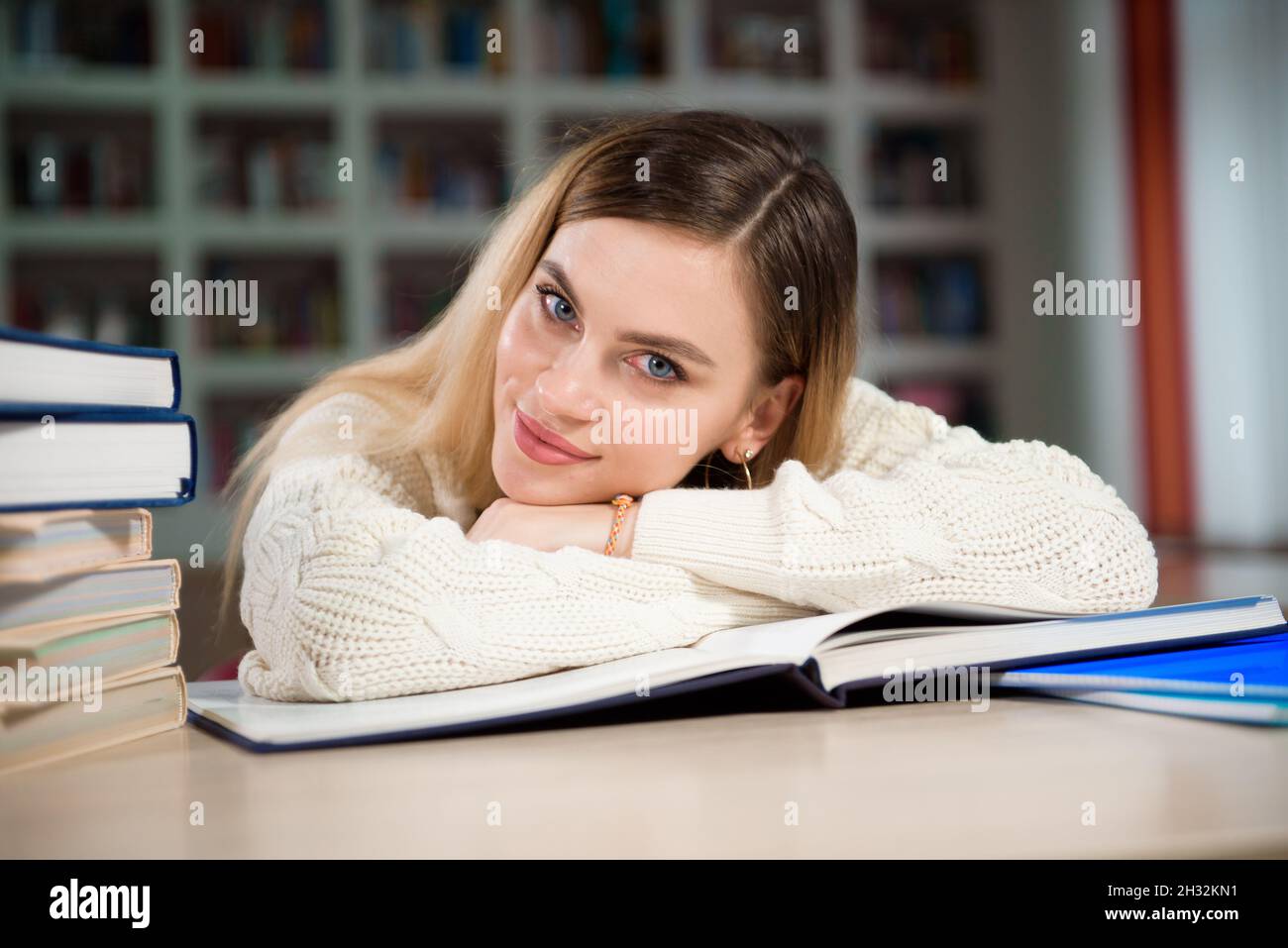 A tired student is studying in the school library Stock Photo - Alamy