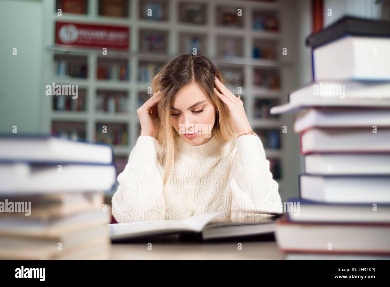 A tired student is studying in the school library Stock Photo - Alamy