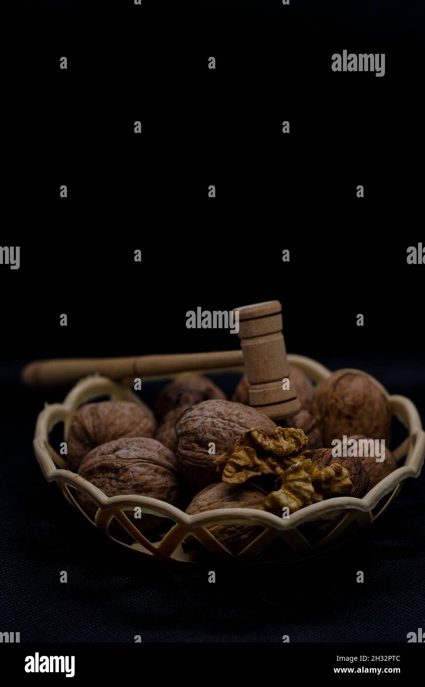 walnuts in a basket with a hammer Stock Photo