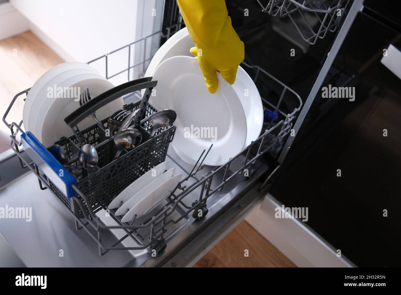 Loading dishes into the dishwasher, plate, fork, spoon Stock Photo Alamy