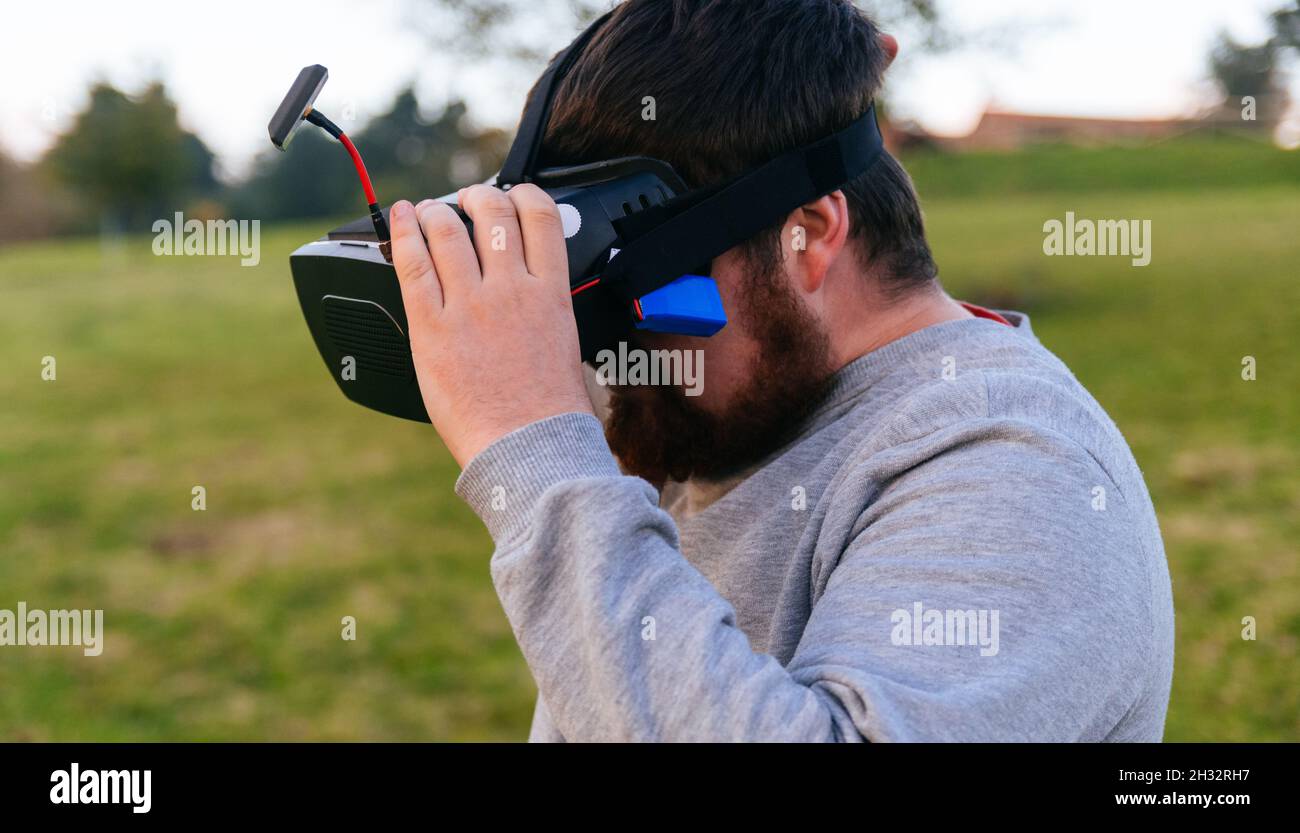 Man holding his virtual reality goggles to fly his fpv drone. Stock Photo