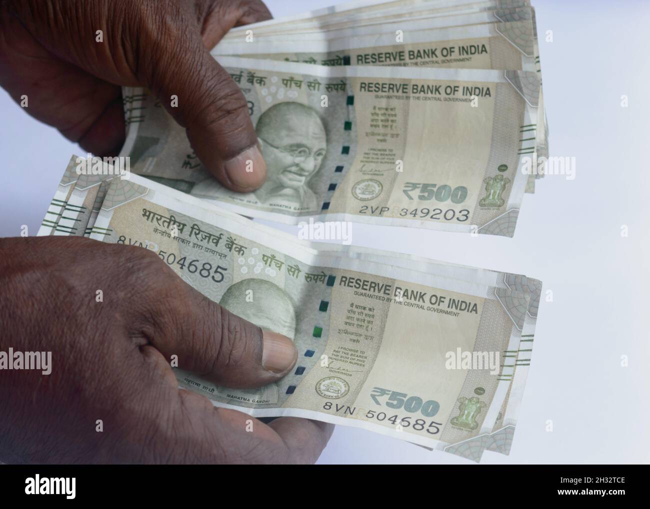 Senior aged Man hand counting Indian rupee note on table. High angle view. Close up. Stock Photo