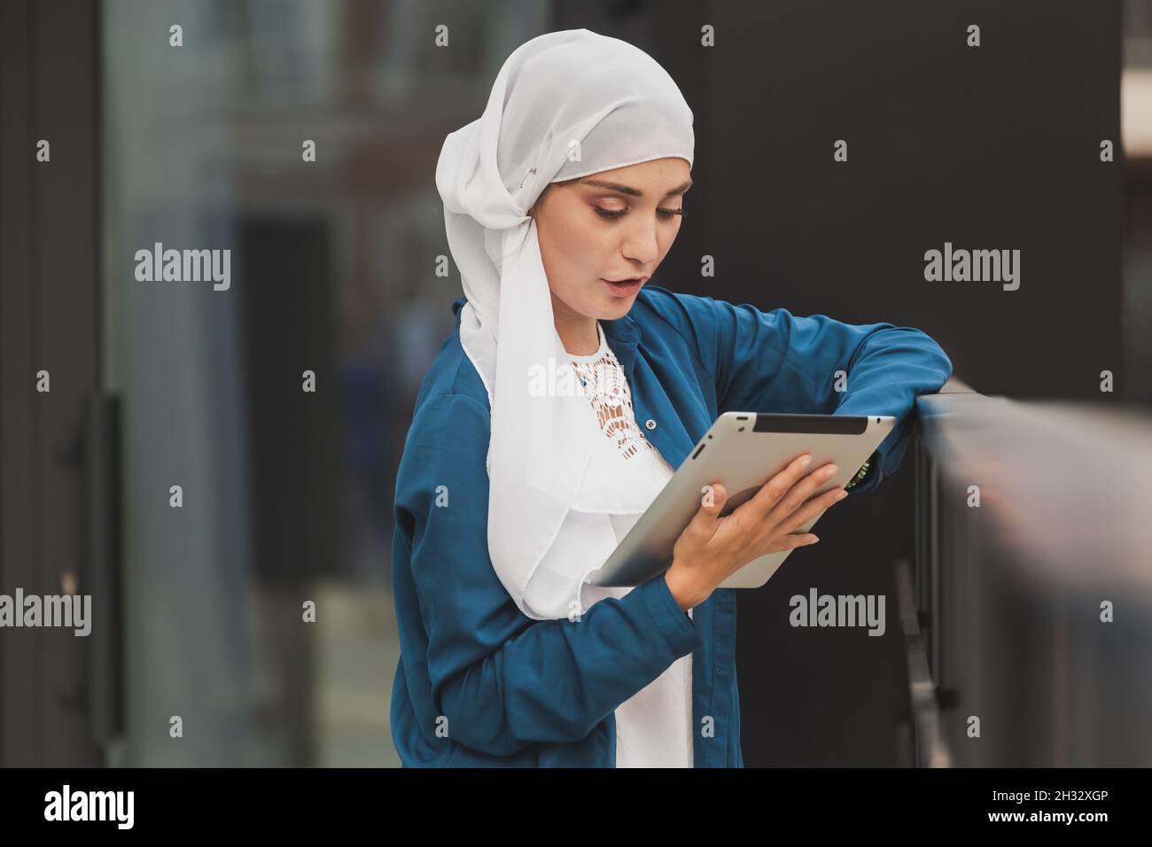 Smiling muslim girl using digital tablet, browsing Internet or social ...