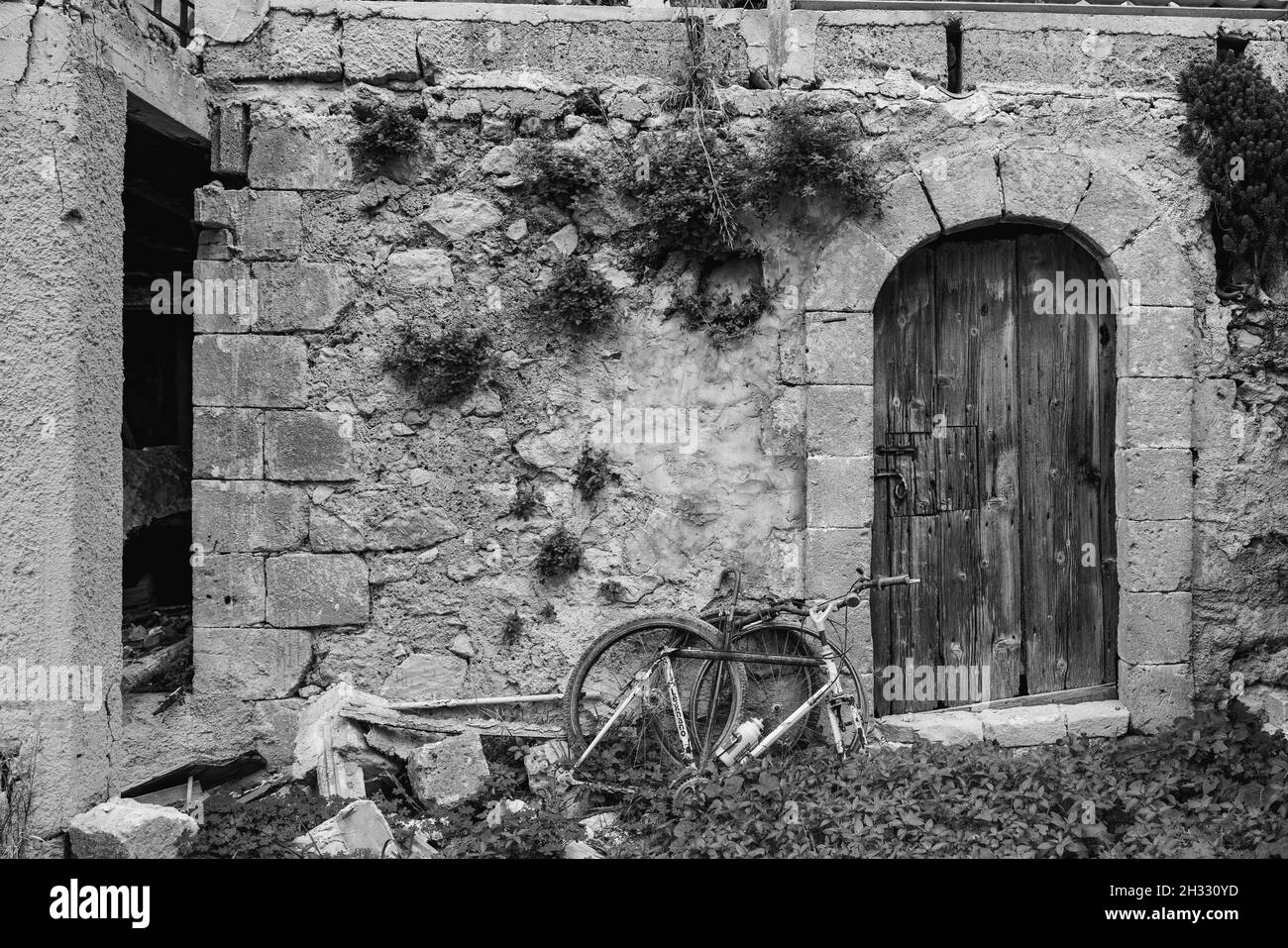 A former bicycle and the door of the farmhouse Stock Photo