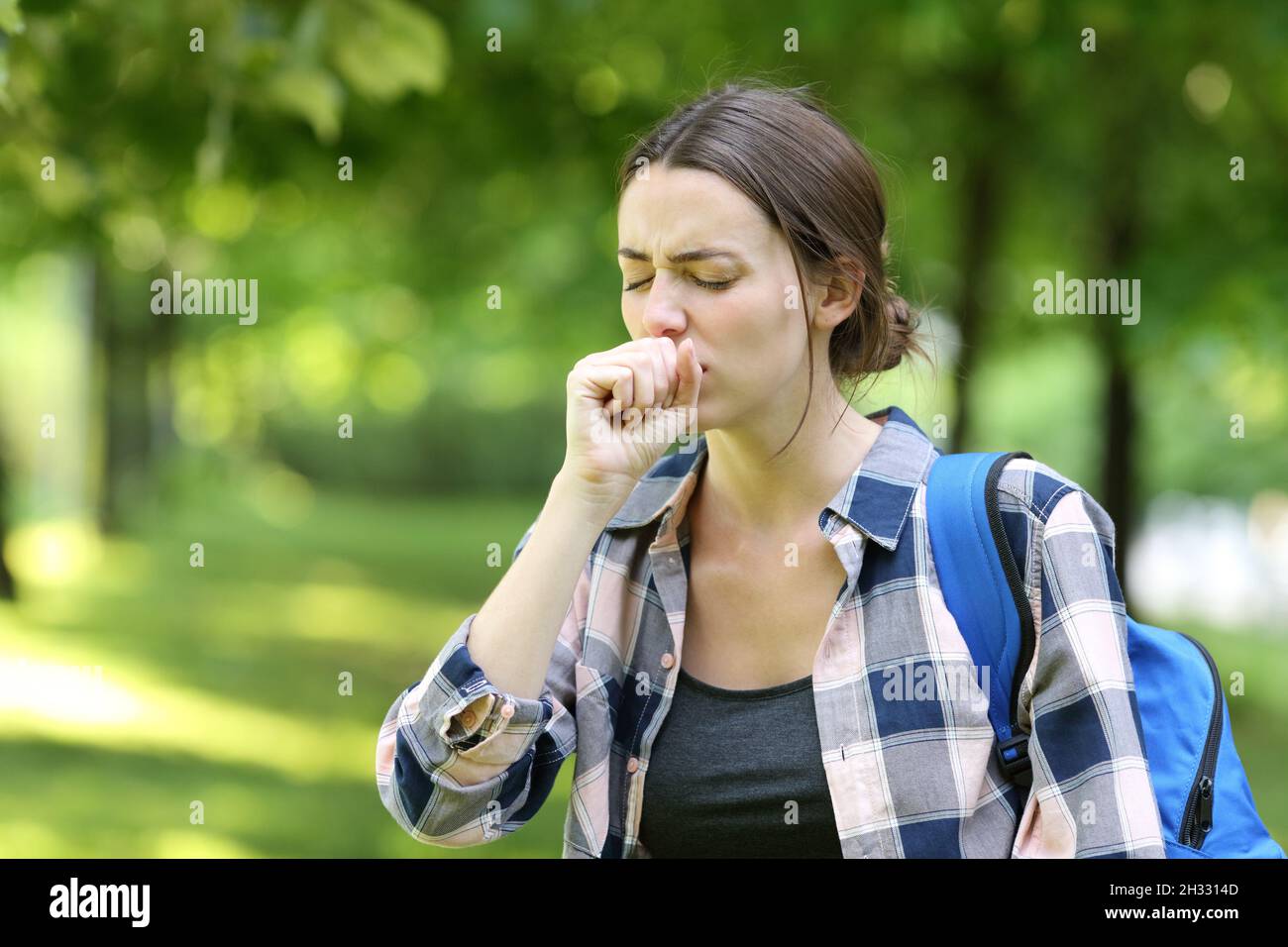 Ill student coughing walking in a campus Stock Photo