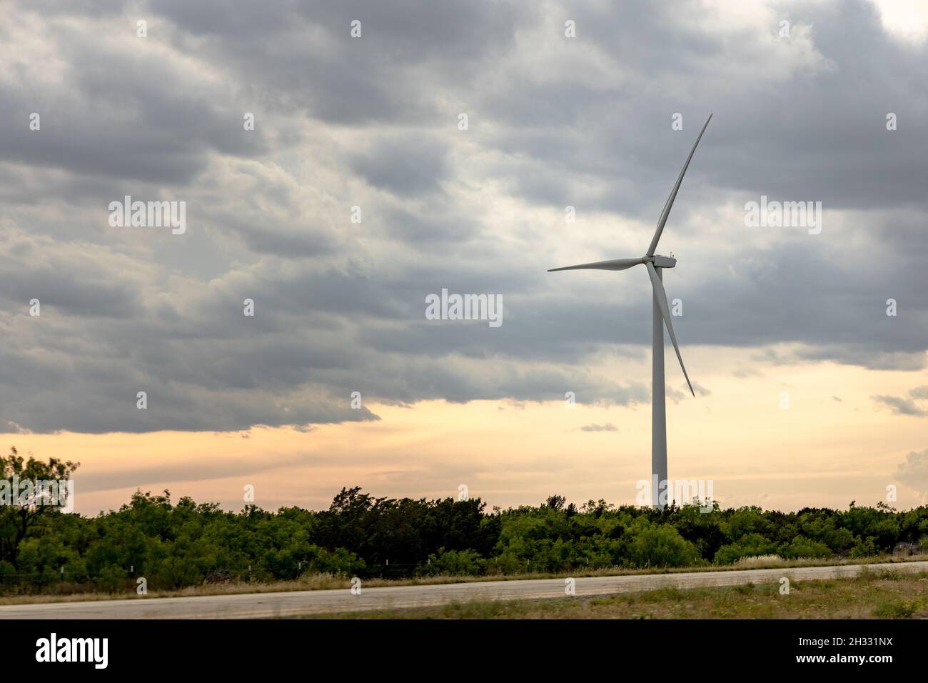Wind turbine under a cloudy sky while driving through Texas Stock Photo ...