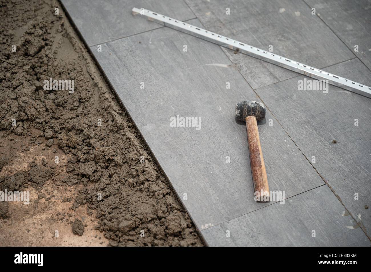 Mallet and tools on granite tile during laying floor Stock Photo