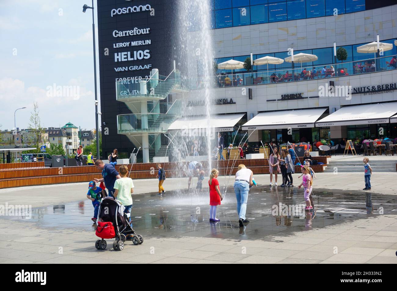 POZNAN, POLAND - May 14, 2017: People having fun around a water fountain in  front of the Posnania shopping mall on a sunny day Stock Photo - Alamy