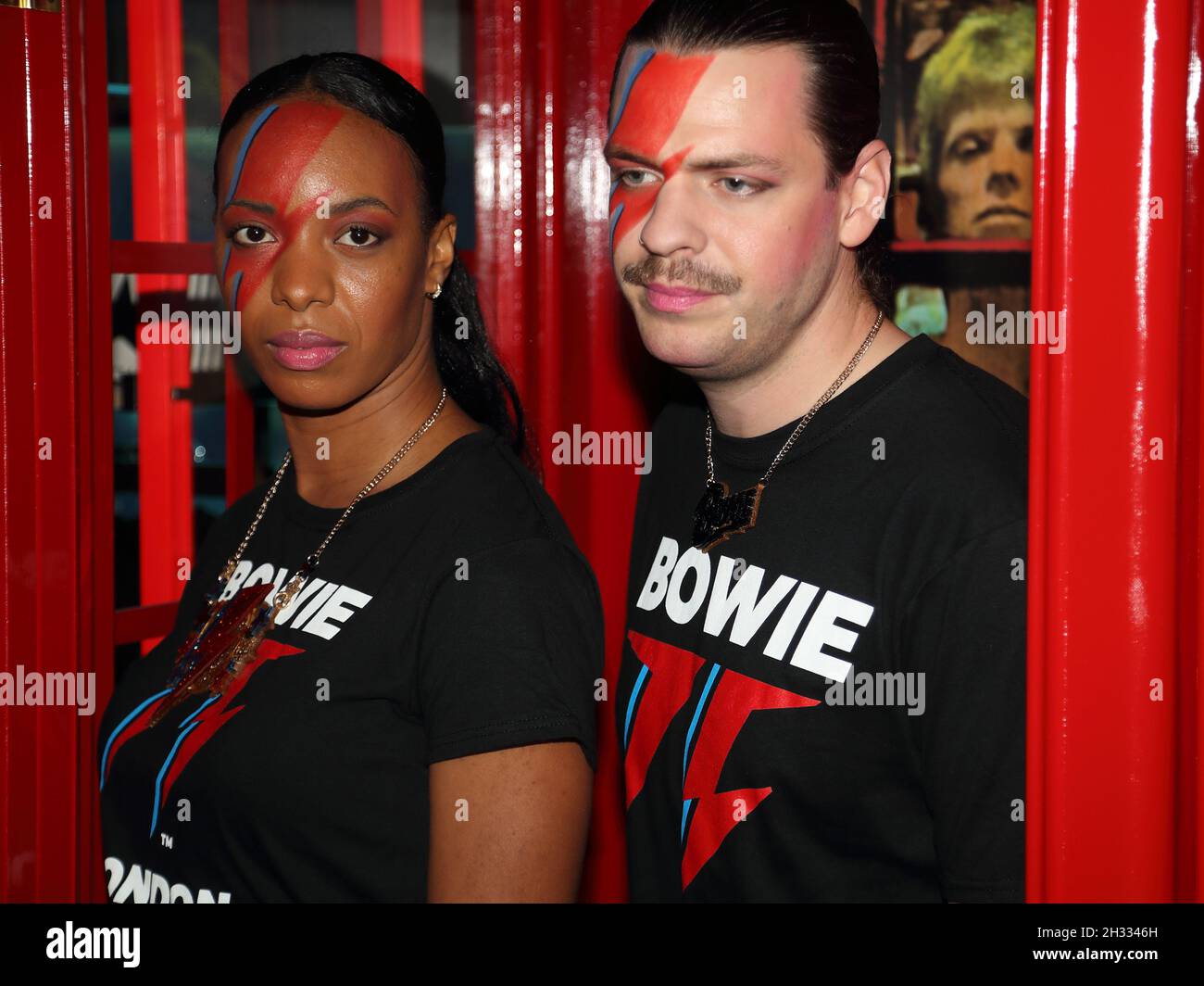 London, UK. 25th Oct, 2021. London, UK, October 25th. A pop up store is opening in Heddon Street to mark what would have been his 75th birthday offering David Bowie items. Two members of staff with Ziggy Stardust makeup pose in the iconic phone booth. Credit: Uwe Deffner/Alamy Live News Stock Photo