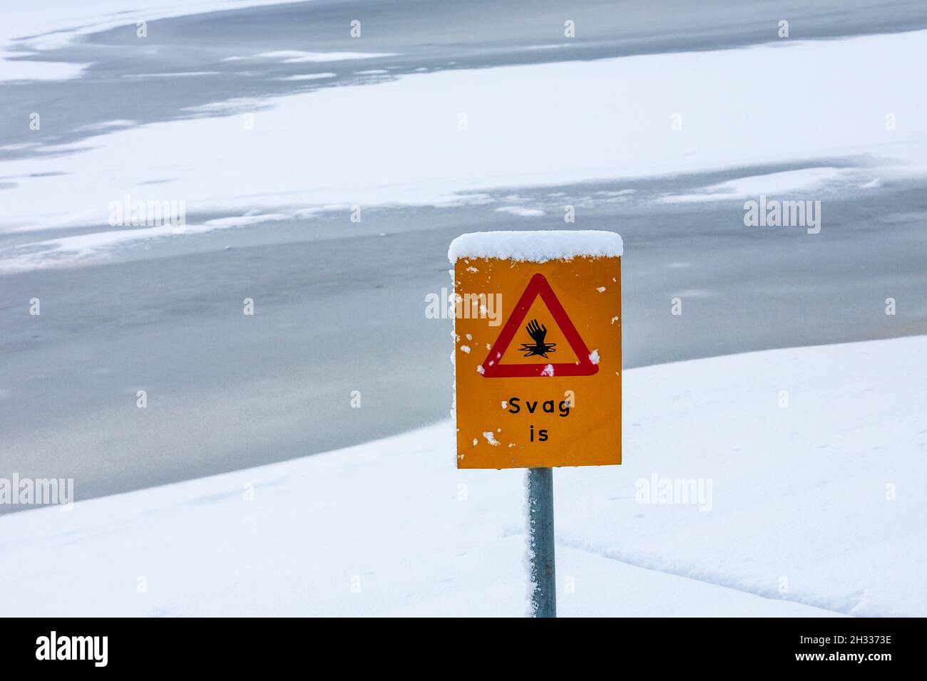 Thin ice warning sign by a lake Stock Photo