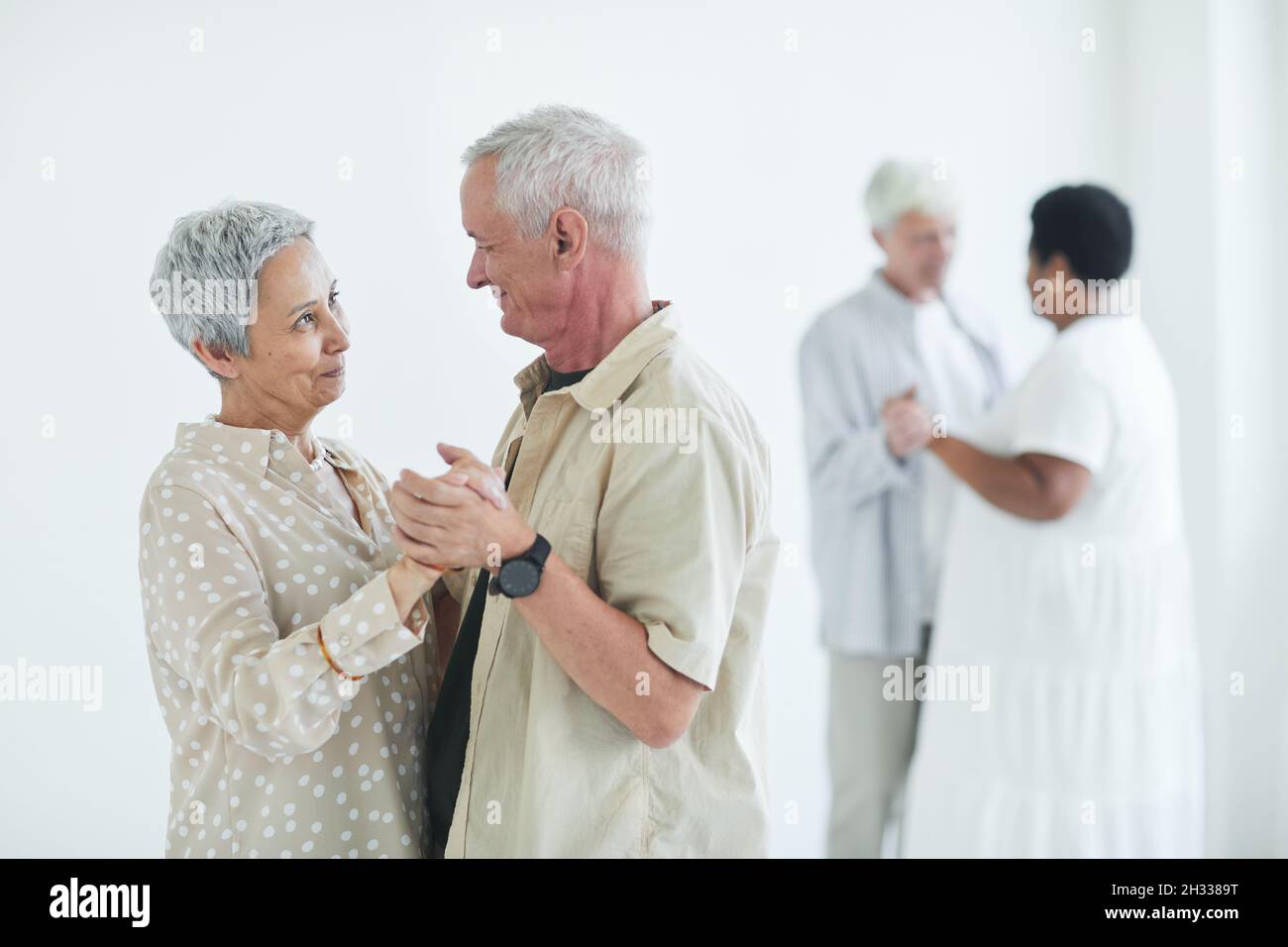 Affectionate elderly couple learning to dance together in dance studio Stock Photo