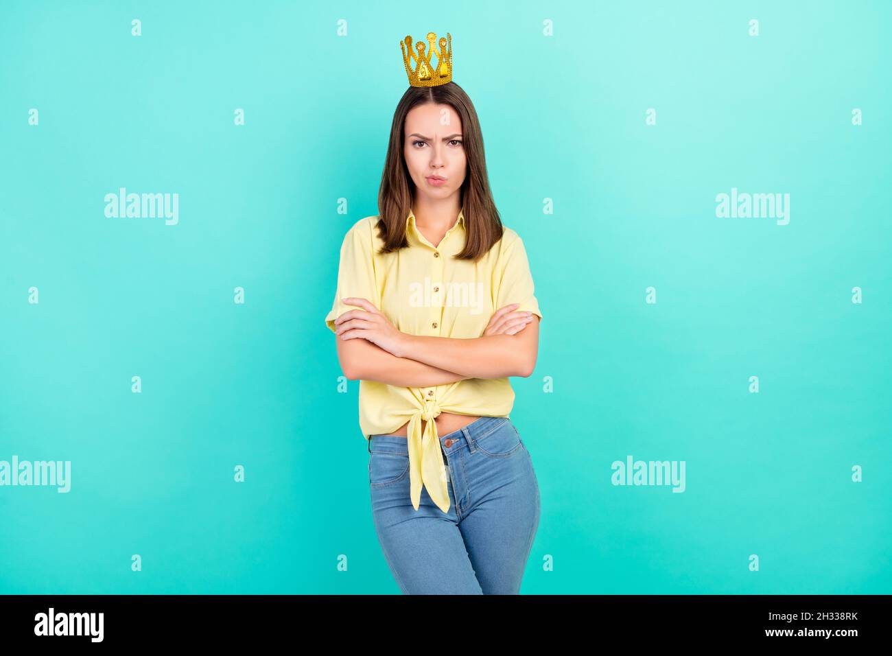 Photo of mad millennial brunette lady crossed arms wear tiara yellow top isolated on teal color background Stock Photo