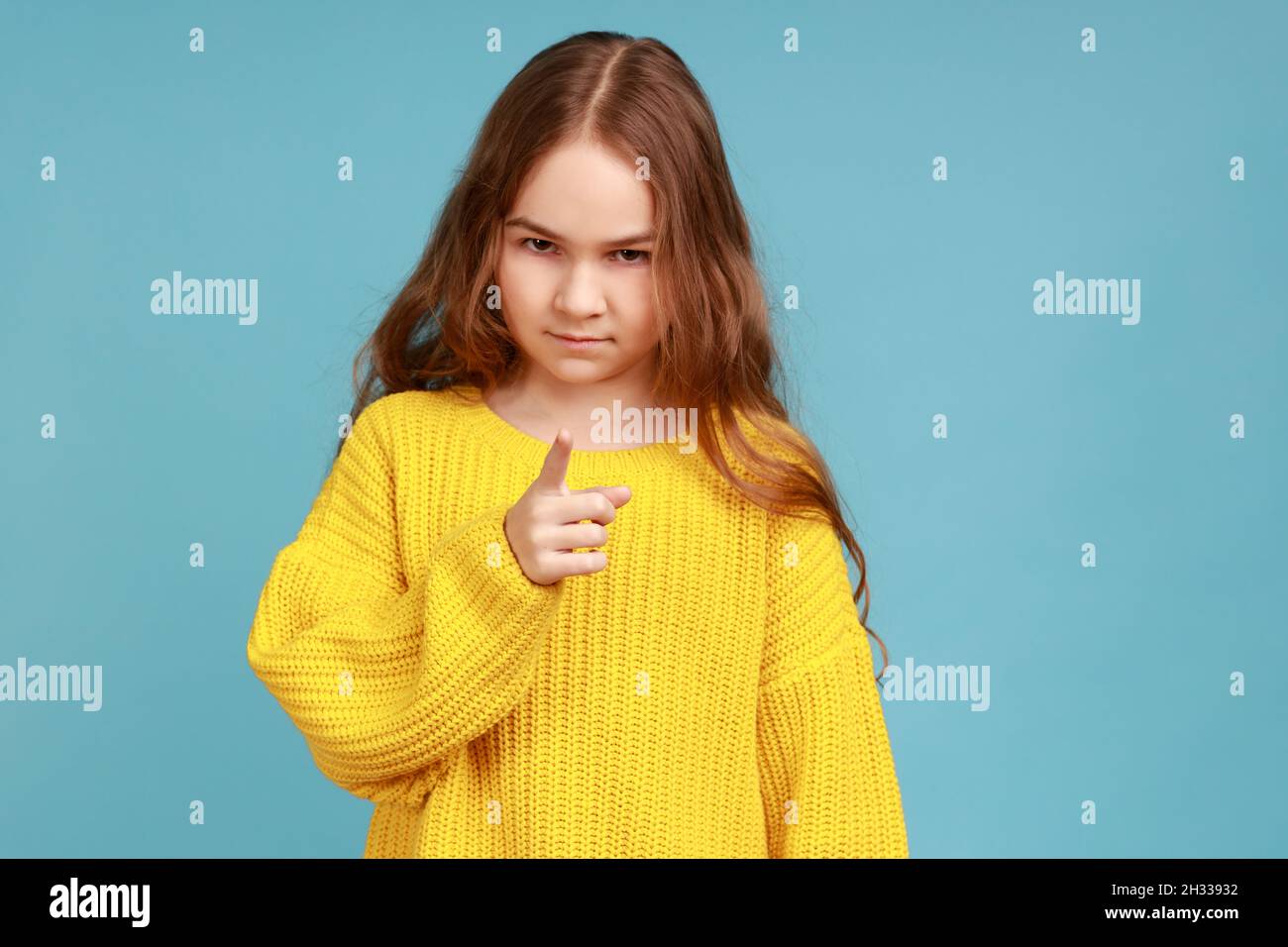 https://c8.alamy.com/comp/2H33932/portrait-of-little-girl-standing-with-admonishing-gesture-warning-looking-with-strict-expression-wearing-yellow-casual-style-sweater-indoor-studio-shot-isolated-on-blue-background-2H33932.jpg