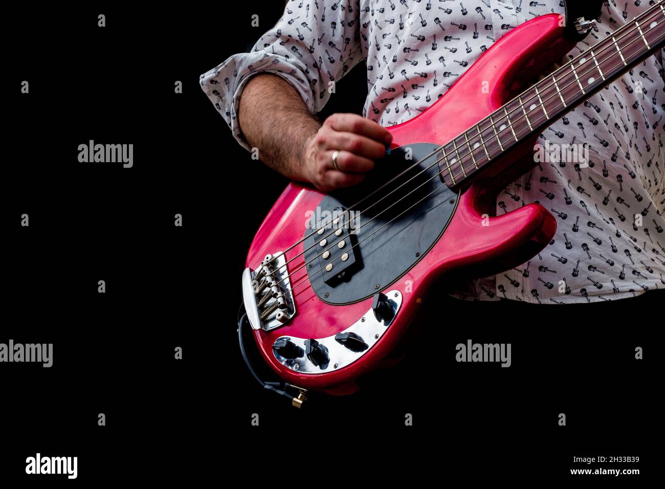 Performance of the rock band. The guitarist plays alone. Black background. Stock Photo